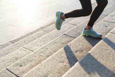Merdivenlerden yukarı koşan bir fitness kadınının yakınlığı