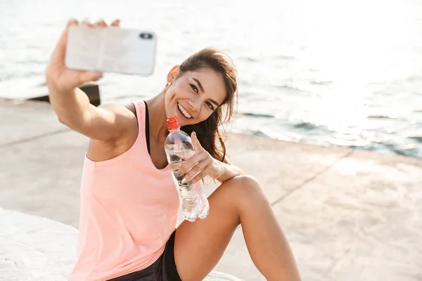 Fröhliche junge Sportlerin ruht sich nach dem Training aus — Stockfoto