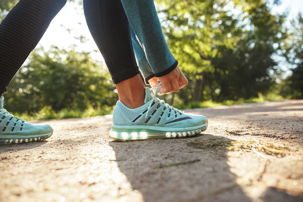 Close up of a fitness woman tying her shoelace — Stock Photo, Image