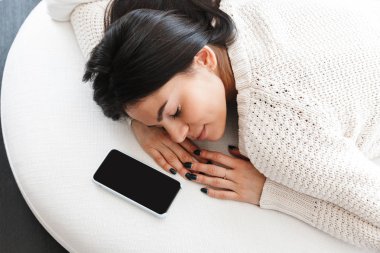 Güzel genç kadın evde bir kanepede rahatlatıcı