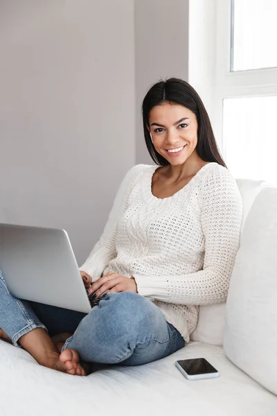 Pretty ung kvinna koppla av på en soffa hemma — Stockfoto