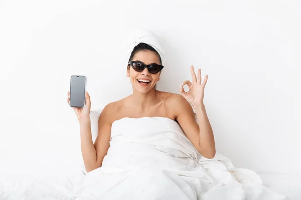 Зображення стильної жінки 30s в сонцезахисних окулярах, загорнуті в ковдру — стокове фото