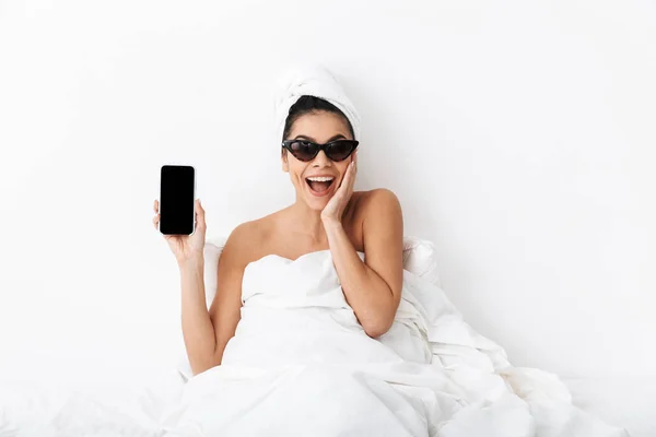 Зображення щасливої жінки 30s в сонцезахисних окулярах, загорнуті в ковдру l — стокове фото