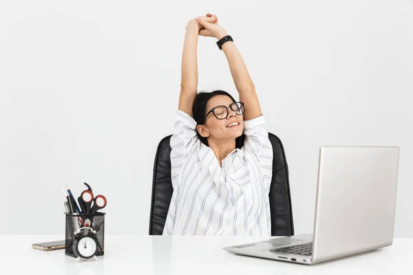 Foto de mujer de negocios morena inteligente 30s estiramiento mientras sitti — Foto de Stock