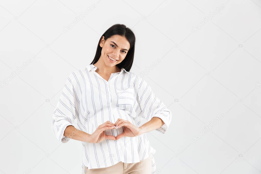 Image of healthy pregnant woman 30s smiling and showing heart sh