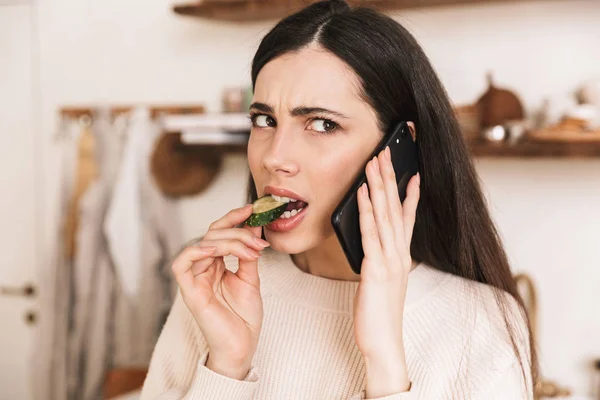 Foto de mujer morena caucásica de 30 años comiendo pepino mientras ta — Foto de Stock