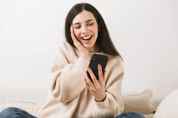 Foto einer attraktiven kaukasischen Frau mit Handy im Sitzen — Stockfoto