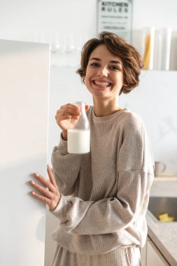 Süt içen Gülen esmer kadının dikey görüntüsü