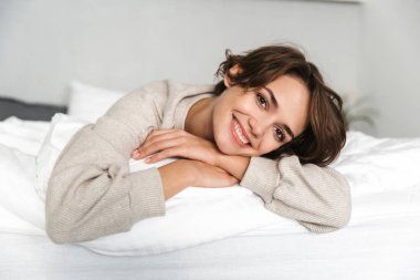 Gülümseyen esmer kadın dinlenme ve kameraya bakarak