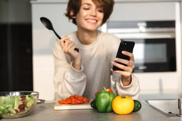 Kép a mosolygó barna nő használ smartphone — Stock Fotó