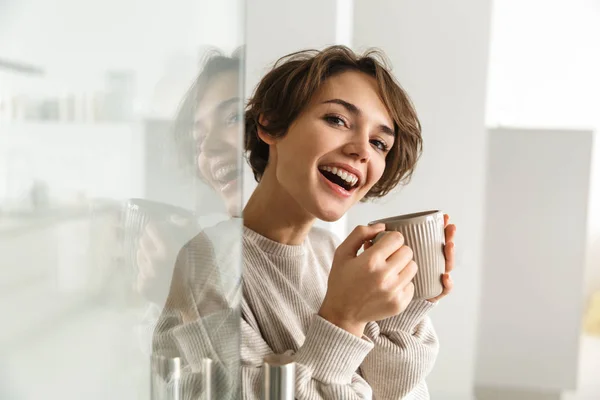 Vista laterale della donna bruna felice che beve caffè — Foto Stock