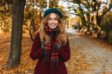 Sonbahar giyen uzun kahverengi saçlı neşeli genç kız