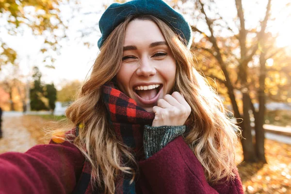 Весела молода дівчина з довгим коричневим волоссям, що носить осінь — стокове фото