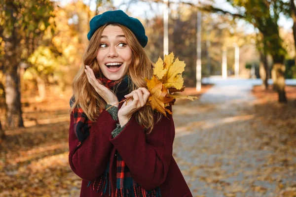 Sonbahar giyen uzun kahverengi saçlı neşeli genç kız
