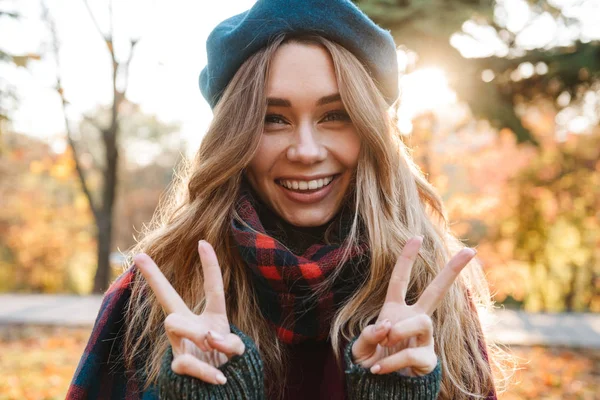 Весела молода дівчина з довгим коричневим волоссям, що носить осінь — стокове фото