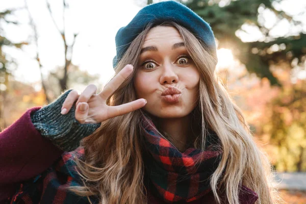 Sonbahar giyen uzun kahverengi saçlı neşeli genç kız