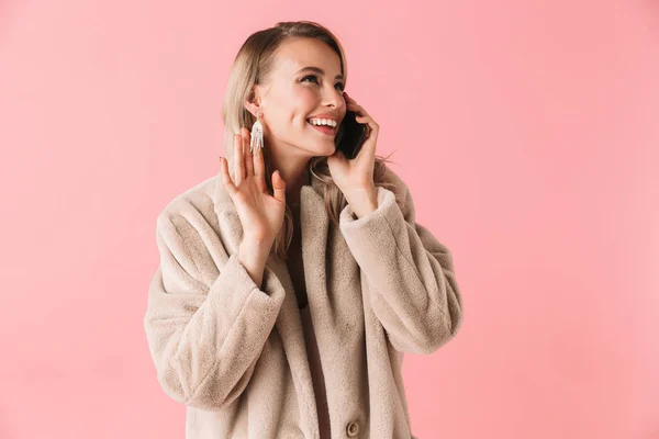 Vrolijke blonde vrouw dragen in bontjas praten met smartphone — Stockfoto
