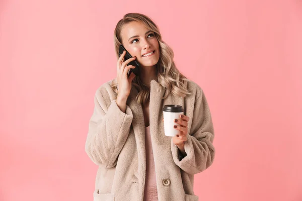 Mujer rubia sonriente usando abrigo de piel hablando por teléfono inteligente — Foto de Stock
