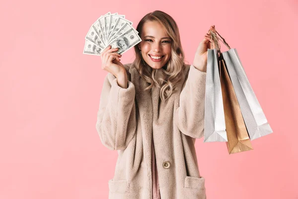 Spokojená žena v kožním kabátě s penězi a balíky — Stock fotografie
