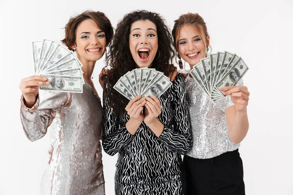 Tiga wanita cantik ceria mengenakan pakaian mengkilap memegang uang — Stok Foto
