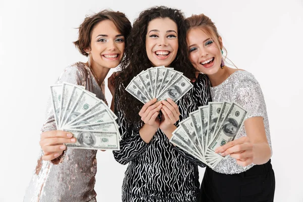 Tři krásné ženy v lesklých šatech, držící peníze — Stock fotografie