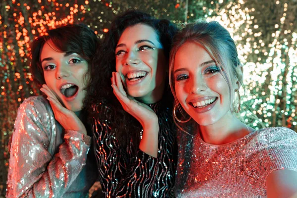 Glimlachend drie schoonheid vrouwen dragen in glanzende kleding — Stockfoto