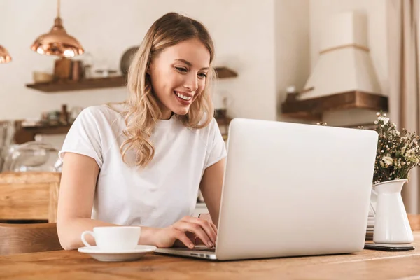 Porträtt av ung blond kvinna som arbetar på laptop och dricka COF — Stockfoto
