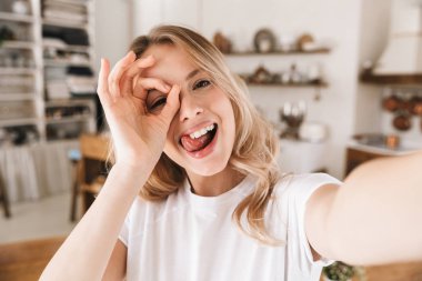 Komik sarışın kadın görüntü yakın çekim kamera bakarak ve alarak 