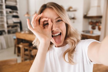 Kameraya bakarak ve alarak neşeli sarışın kadın Görüntü closeup