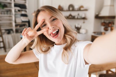 Ta sırasında barış işareti gösteren eğlenceli sarışın kadın Görüntü closeup