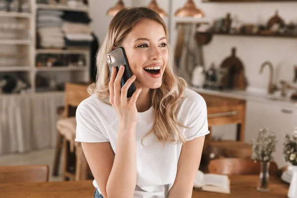 Portrait einer blonden Frau, die während ihres Studiums mit dem Handy telefoniert — Stockfoto