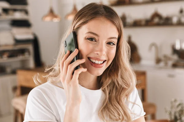 Portré csinos szőke nő beszél a mobiltelefonján, miközben állni — Stock Fotó