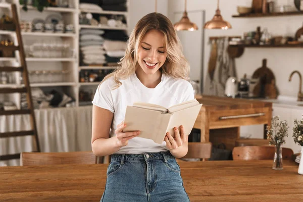 Porträtt av vacker blond kvinna läsa bok medan du står i — Stockfoto