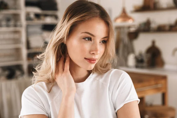 Retrato de la encantadora chica rubia sonriendo y mirando a un lado mientras — Foto de Stock