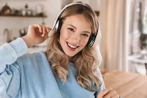 Retrato de la encantadora chica rubia de 20 años con auriculares escuchando —  Fotos de Stock