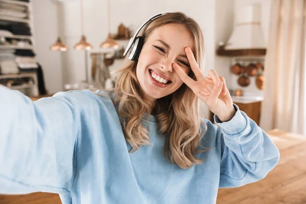 Πορτρέτο της καυκάσιας ξανθιά κορίτσι 20s φορώντας ακουστικά χαμογελαστά — Φωτογραφία Αρχείου