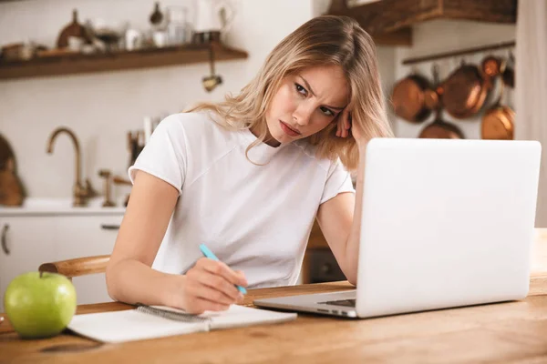 Imagen de la mujer rubia triste estudiando en el ordenador portátil y escribiendo no — Foto de Stock