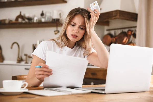 Image d'une femme blonde triste tenant une carte de crédit en plastique tandis que looki — Photo