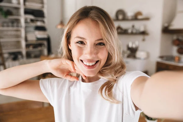 Image closeup of young blond woman looking at camera and taking — Stock Photo, Image