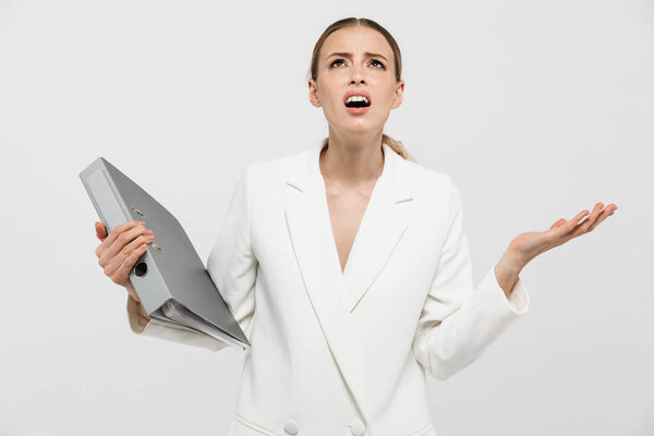Beautiful displeased nervous woman posing isolated over white wall background holding folder.