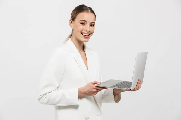 Vacker lycklig fantastisk kvinna poserar isolerade över vit vägg bakgrund med hjälp av bärbar dator. — Stockfoto