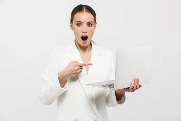 Linda chocado animado incrível mulher posando isolado sobre fundo da parede branca usando computador portátil . — Fotografia de Stock