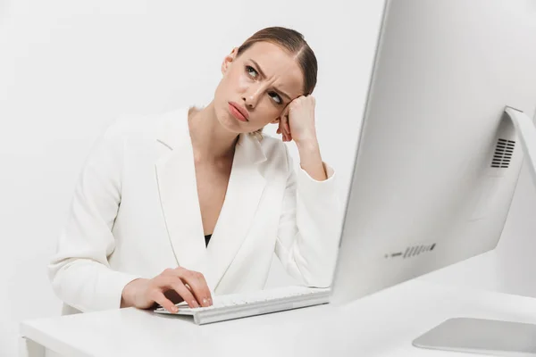 Missnöjd vacker fantastisk kvinna sitter isolerad över vit vägg bakgrund med hjälp av PC-dator. — Stockfoto