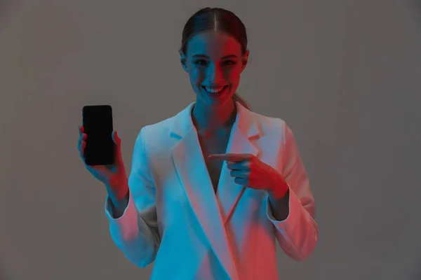 Imagen de primer plano de la mujer de la moda de 20 años sosteniendo el teléfono móvil y mostrar — Foto de Stock
