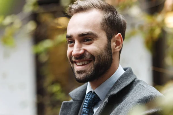 Sonriente joven hombre de negocios usando traje caminando —  Fotos de Stock