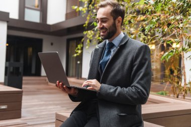 Çekici genç işadamı yürüyüş takım elbise giyiyor