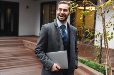 Çekici genç işadamı yürüyüş takım elbise giyiyor