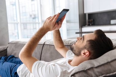 Esmer adam tutarak ve akıllı telefon kullanarak fotoğraf o yalan