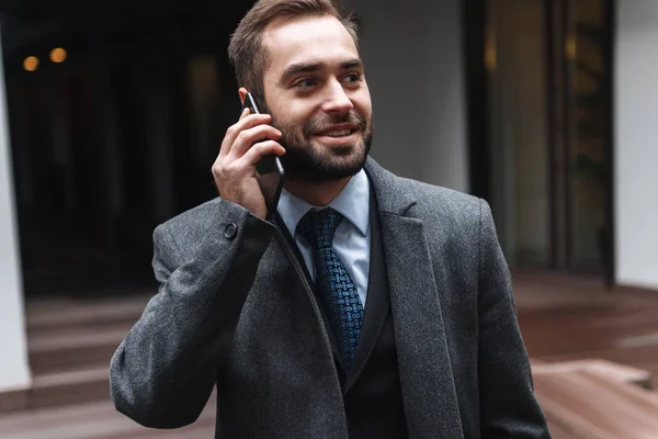 Atractivo joven hombre de negocios usando traje caminando — Foto de Stock