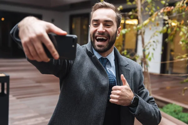 Aantrekkelijke lachende jonge zakenman dragen pak — Stockfoto